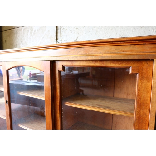 698 - Mahogany three-door sliding door bookcase raised on plinth. 