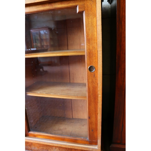 698 - Mahogany three-door sliding door bookcase raised on plinth. 