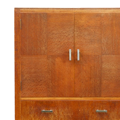 Art Deco limed oak tallboy by Heals of London, the twin-cabinet doors having quarter panel veneer, above three graduated drawers, impressed Heal's button to top drawer, 43 x 130 x 47cm.