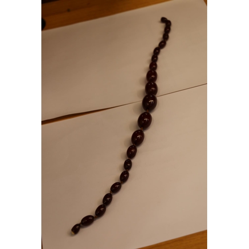 213 - Strand of 21 graduated cherry coloured amber beads, 41.5g gross.