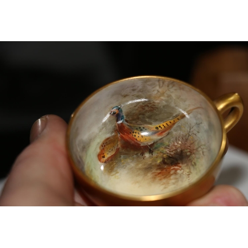 504 - Royal Worcester porcelain cabinet cup and saucer decorated with pheasant design and signed 'Jas Stin... 