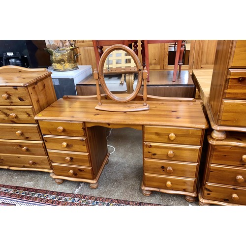 562 - Pine bedroom suite comprising dressing table with cheval mirror, two over four chest of drawers, and... 