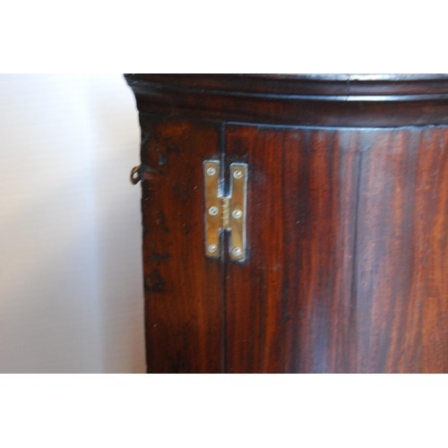 409 - 18th century mahogany bowfront corner cupboard with two doors enclosing a shelved interior above thr... 