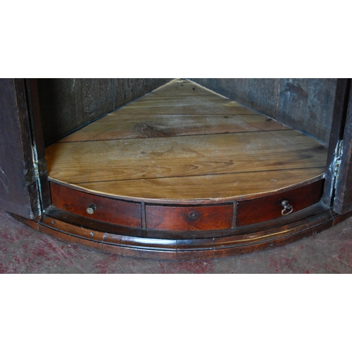 409 - 18th century mahogany bowfront corner cupboard with two doors enclosing a shelved interior above thr... 