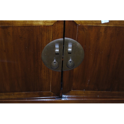 407 - Pair of Chinese elm cupboards (last quarter 20th century) of low form with two doors enclosing a she... 