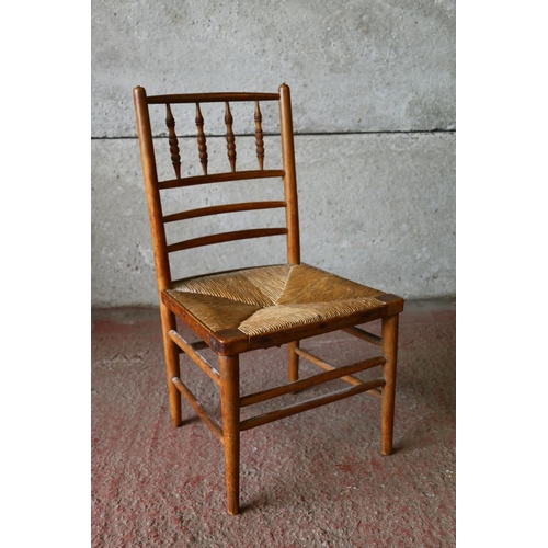 841 - Child's beech chair, with spindle back and rush seat, raised on turned supports, united by stretcher... 