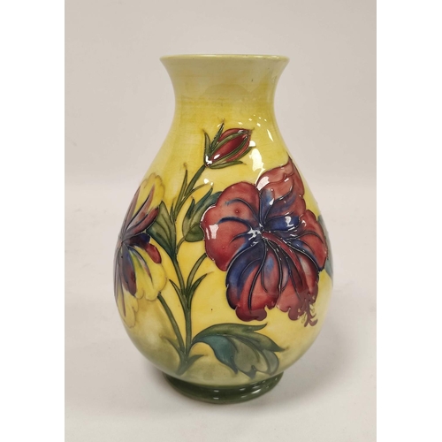 257 - William Moorcroft Hibiscus design pottery vase, the oviform vase tube lined on yellow ground, green ... 