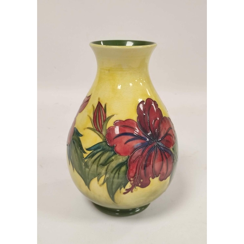 257 - William Moorcroft Hibiscus design pottery vase, the oviform vase tube lined on yellow ground, green ... 