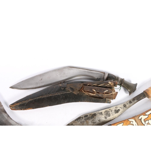 104 - Two Kukri with miniature fork and knife also a eastern dagger in carved wooden sheath  (3)