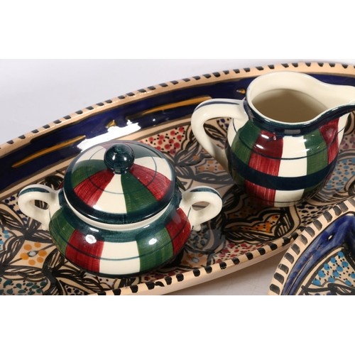 20 - Brightly coloured pottery to include a tagine, a segmented dish, an oval platter etc., also a Tartan... 