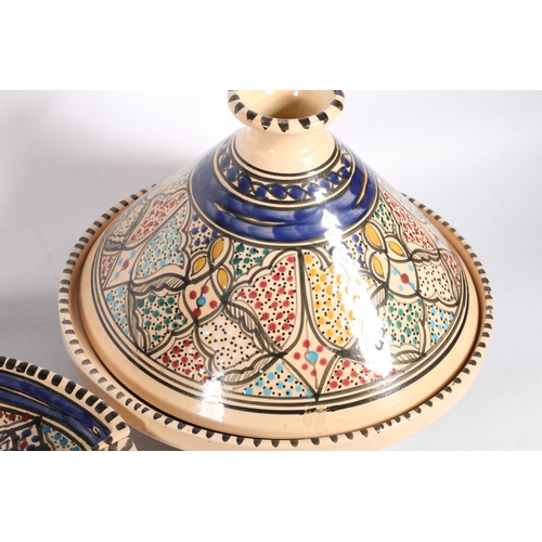 20 - Brightly coloured pottery to include a tagine, a segmented dish, an oval platter etc., also a Tartan... 