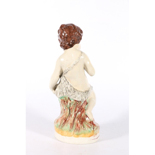 92 - Staffordshire style model of a boy seated on tree stump,  23cm.