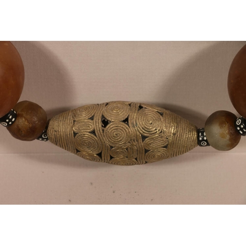 415 - AFRICAN SCHOOL, an elaborate hardstone, glass, seed and white metal necklace in box display frame, 7... 