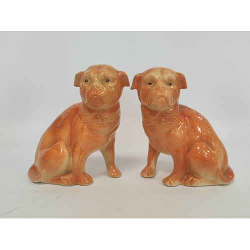 266 - Two early 20th century Staffordshire style ceramic figures modelled as seated pug dogs, with painted... 