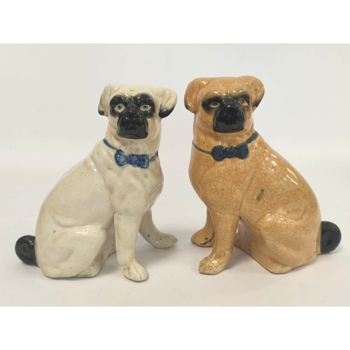 266 - Two early 20th century Staffordshire style ceramic figures modelled as seated pug dogs, with painted... 