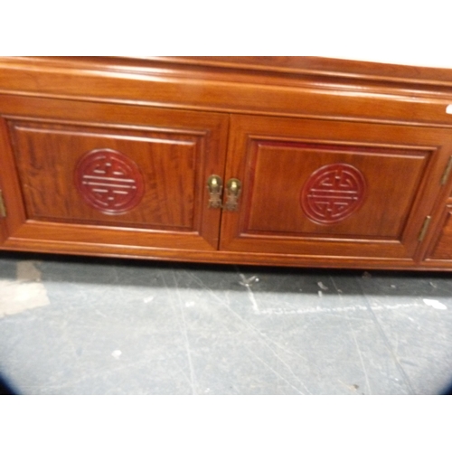 518 - Chinese-style cherry wood low cabinet fitted with central cupboards flanked by drawers.