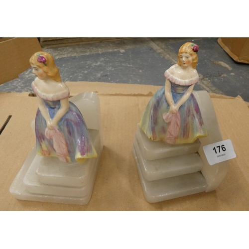 176 - Pair of bookends formed from ceramic figurines standing on stepped base, 16cm high.