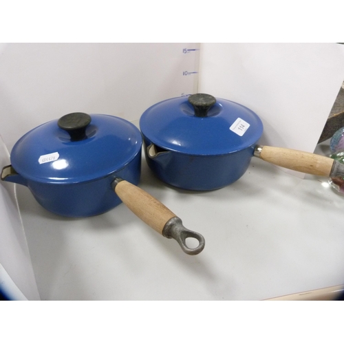 114 - Two Le Creuset pans with covers, glazed in blue, and a set of three Le Creuset graduated oven dishes... 