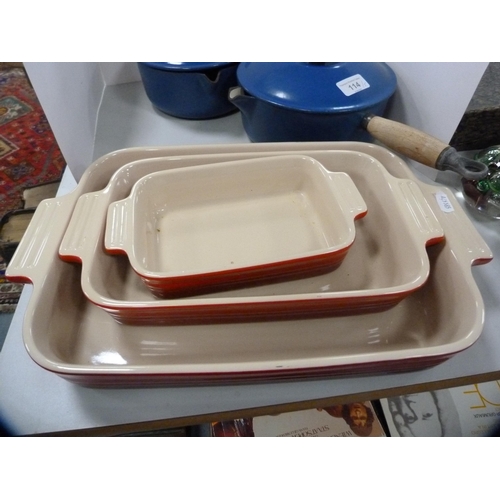 114 - Two Le Creuset pans with covers, glazed in blue, and a set of three Le Creuset graduated oven dishes... 