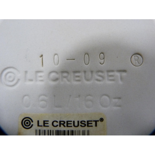 114 - Two Le Creuset pans with covers, glazed in blue, and a set of three Le Creuset graduated oven dishes... 