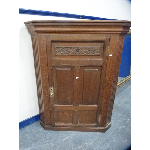 558 - Carved oak corner cupboard enclosed by a single door.