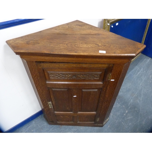 558 - Carved oak corner cupboard enclosed by a single door.