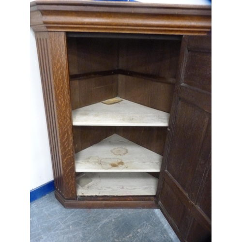 558 - Carved oak corner cupboard enclosed by a single door.