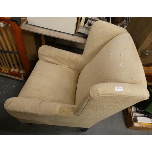 579 - Cream upholstered wing back armchair.