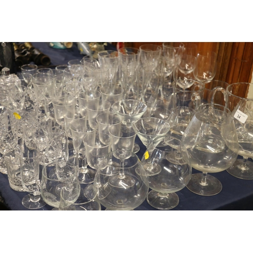 34 - Extensive group of glassware to include brandy balloons, whisky tumblers, a decanter, glasses, champ... 