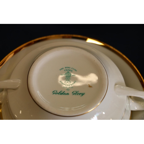 40 - Nine Crown Staffordshire Golden Glory two-handled soup coupes and saucers.