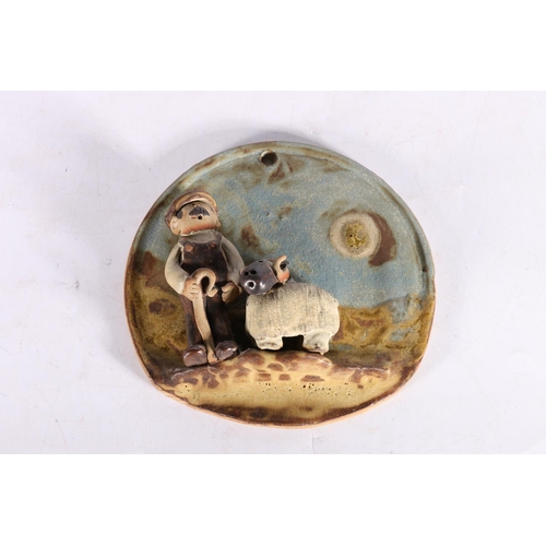 43 - Moffat Pottery circular wall plaque, shepherd with sheep, signed to reverse 'Flockfield' and dated 1... 