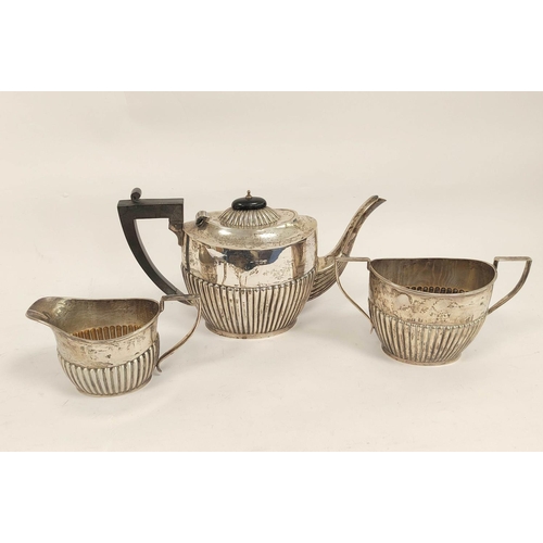 93 - Silver three-piece tea set, part fluted, by Deakins, Birmingham, 1911, also a toast rack, 974g.  (4)