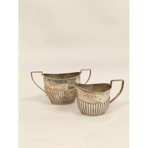 93 - Silver three-piece tea set, part fluted, by Deakins, Birmingham, 1911, also a toast rack, 974g.  (4)