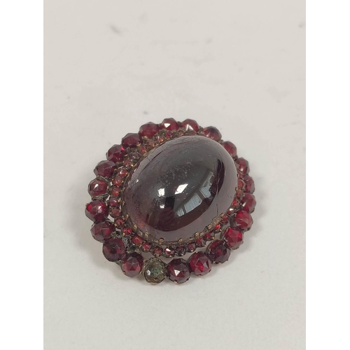 120 - Pyrope garnet oval brooch, with tiered cabochons and the matching drop earrings, 'garnet gold'.  (3)