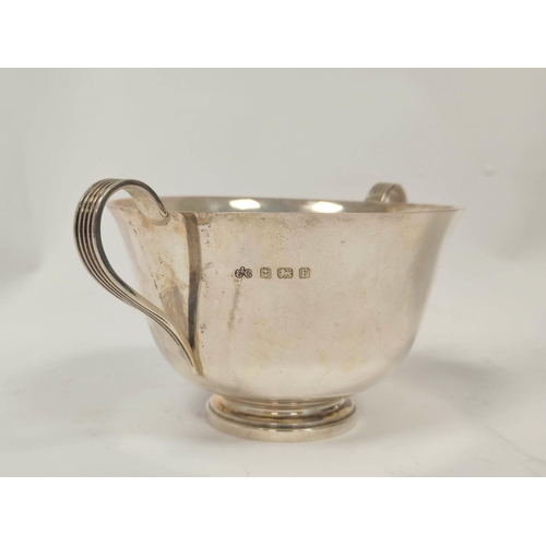 136 - Silver plain porringer with loop handles and a trefid spoon by Elkington, 1929, 212g, cased.  (... 