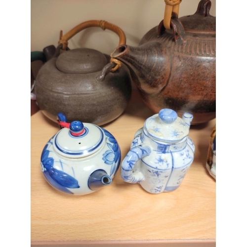 345 - Chinese and Oriental stoneware and clay tea pots to include a brown glazed example with bamboo handl... 