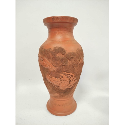 340 - Four Oriental terracotta vases of baluster form and bottle shape, all bearing relief dragon decorati... 