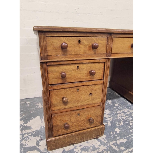 382 - Oak pedestal desk with turned knobs, tooled leather top and long drawer, flanked by four short drawe... 