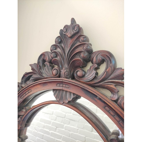 388 - Mahogany fret wall mirror, with scrolled carved frame, the arched top with feather surmount, 189cm h... 