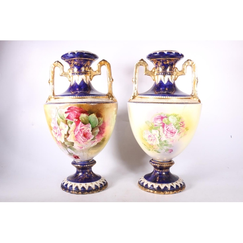 71 - A pair of urns with gilt and floral painted decoration, 42cm high.