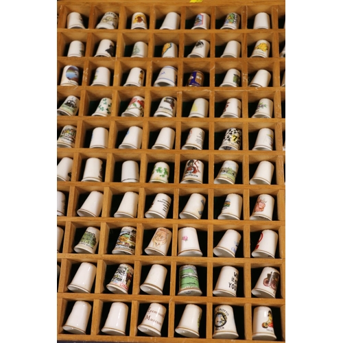 85 - Large collection of porcelain thimbles, with display cabinets.