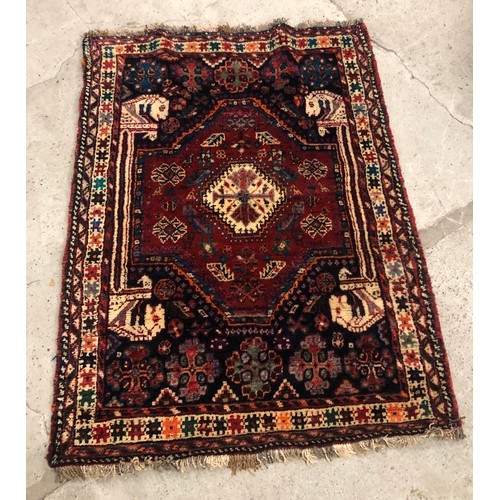 587 - Hand woven middle eastern woollen rug on red ground, 115 x118 cm 