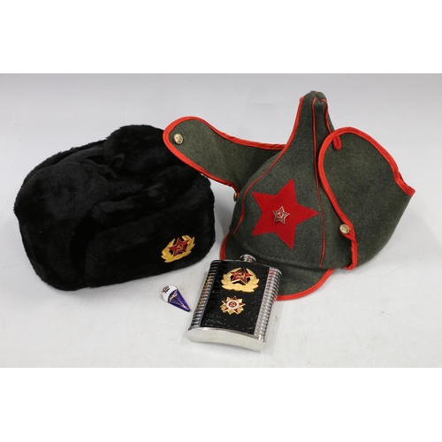 766 - Soviet Russian winter hat with enamelled badge, a replica green cloth peaked hat, a Soviet hip flask... 