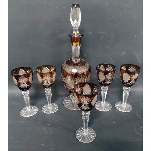 11 - Four cut glass decanters, a flashed amber crystal decanter and five glasses.