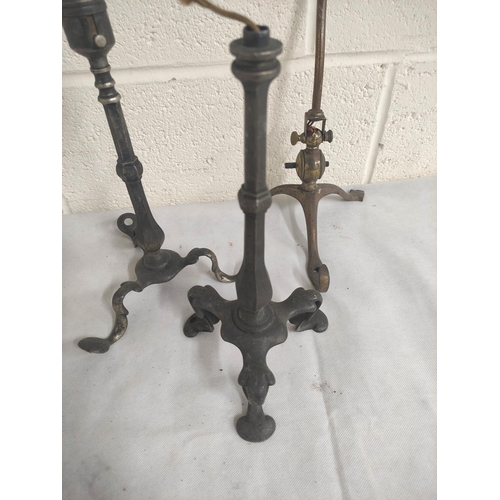 21 - Four antique brass table lamps on scroll supports.