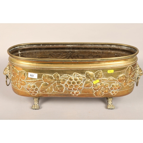 522 - Brass paw foot trough with lion head handles and grape vine design, approx 63cm long