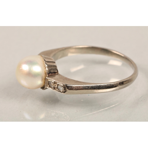 53 - A white metal ring with pearl and diamond chips on shoulders. Size: Q. 