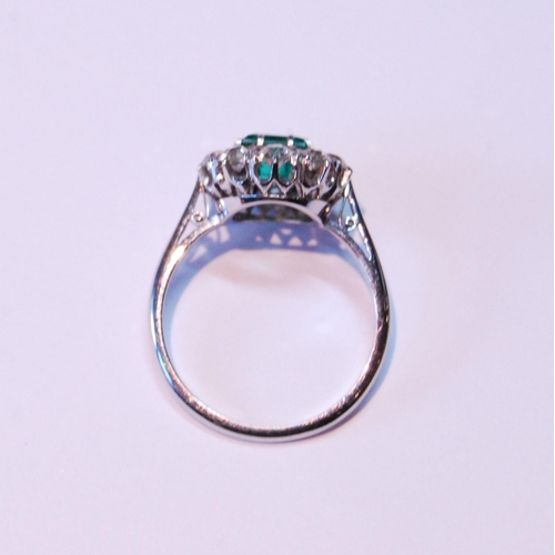 12 - Diamond and emerald oval cluster ring with rectangular emerald, approximately 5.5mm x 6mm, with ten ... 