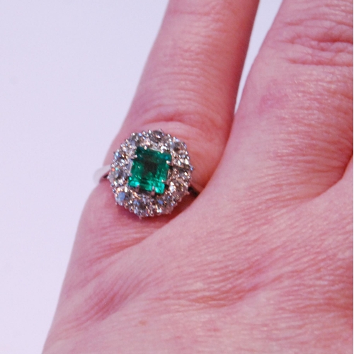 12 - Diamond and emerald oval cluster ring with rectangular emerald, approximately 5.5mm x 6mm, with ten ... 