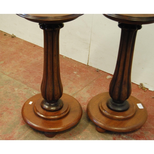 306 - Pair of Victorian mahogany stands, each with a saucer top above a fluted column and circular platfor... 